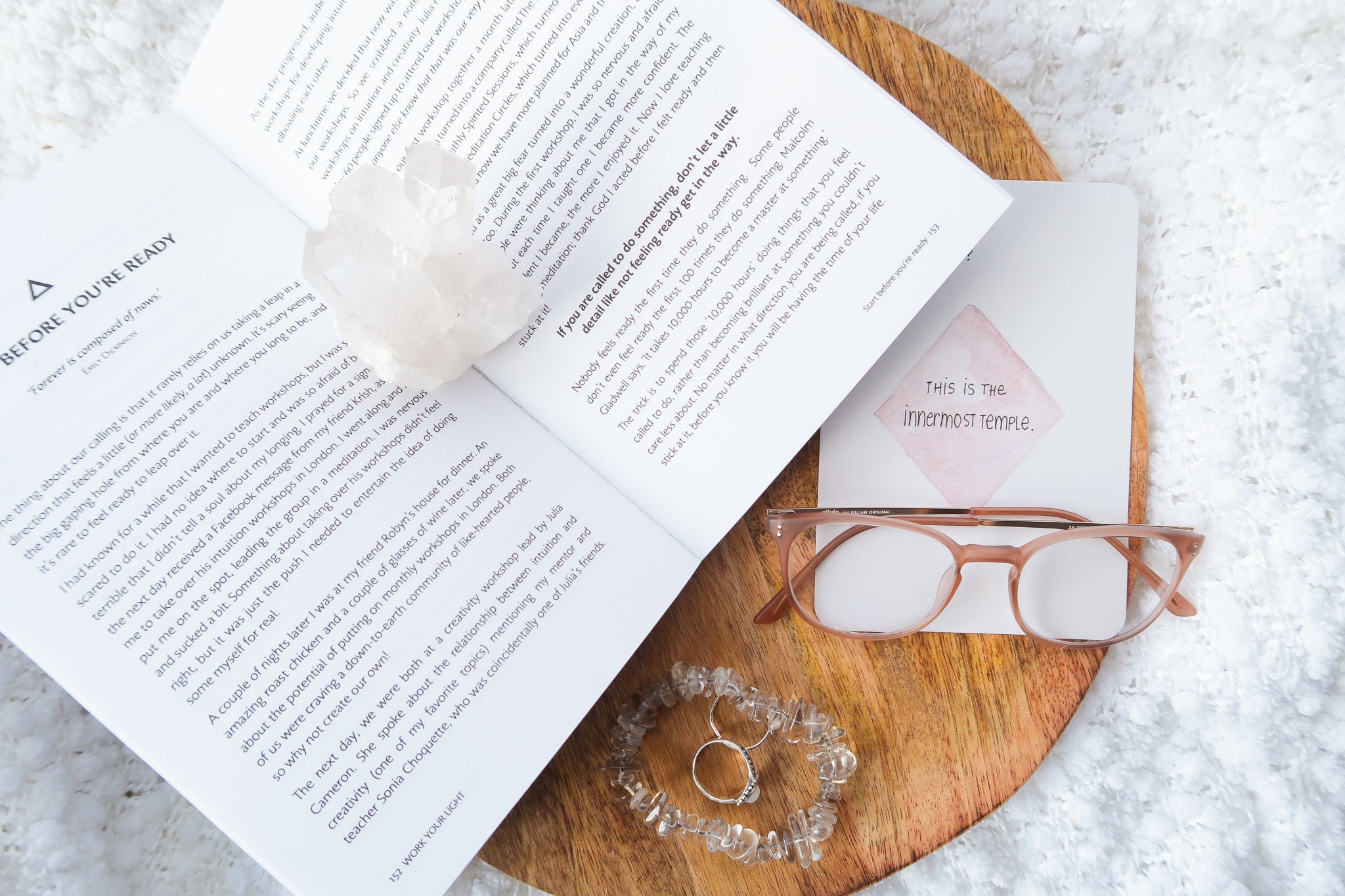 Various Crystal Tumble Stones on a desk with apple Mac laptop, journal, sunglasses