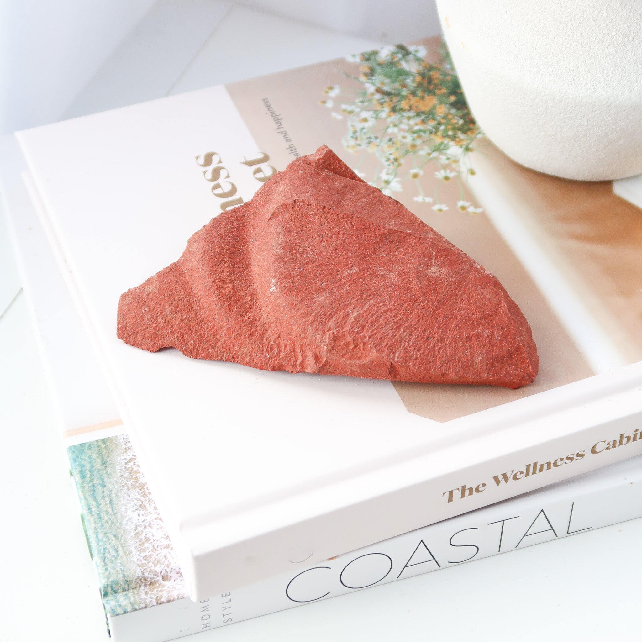 Raw Red Jasper on books with vase