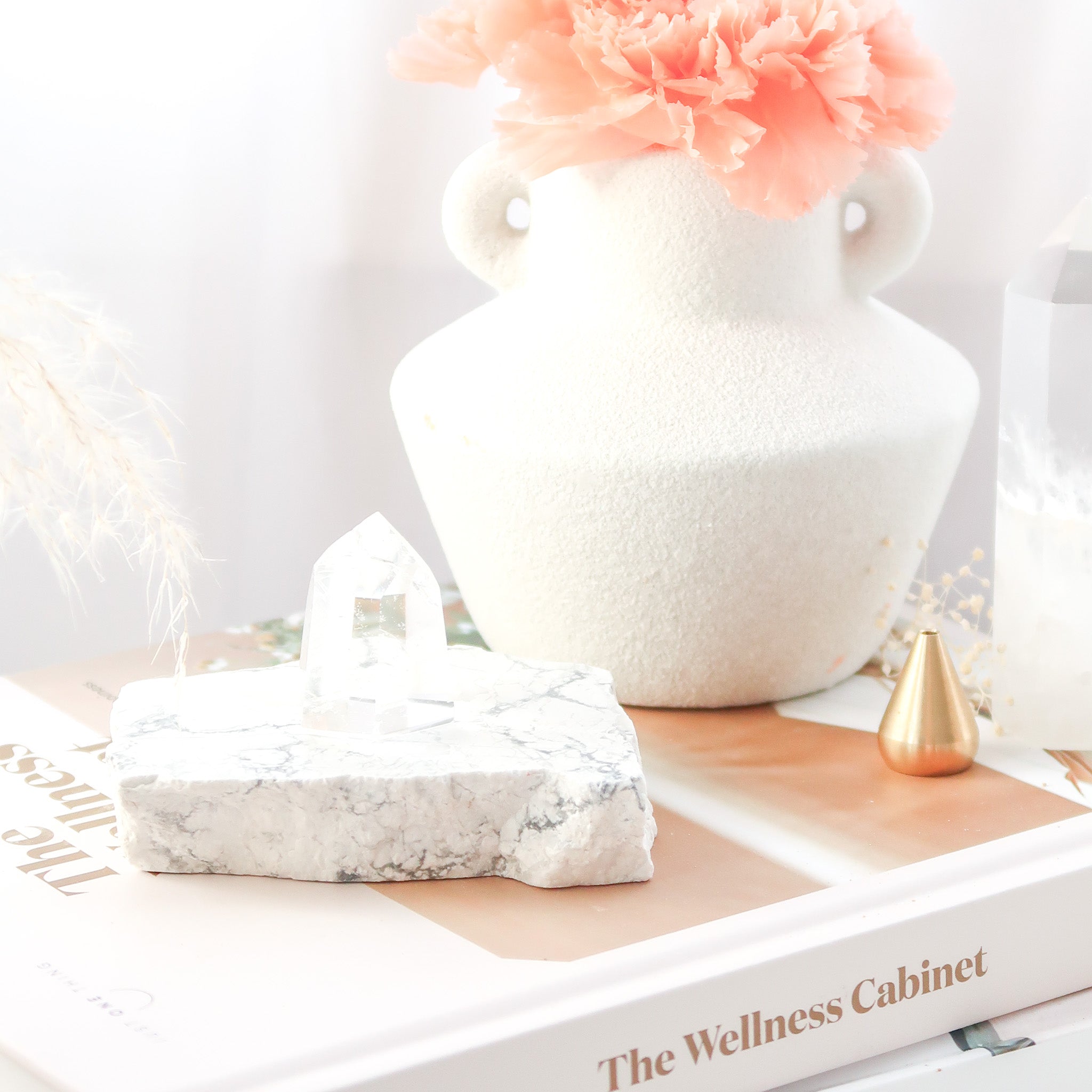 Howlite slab with clear quartz point on books with a vase