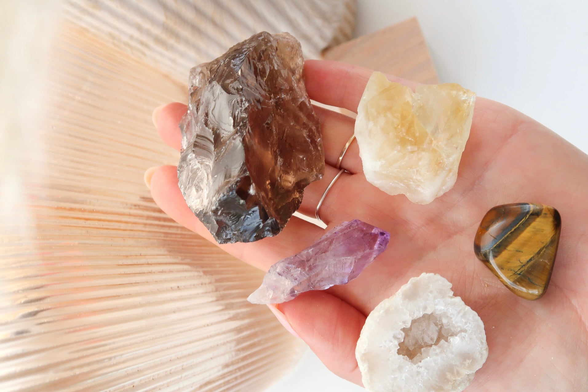 selection of raw and polished crystals being held in a hand 