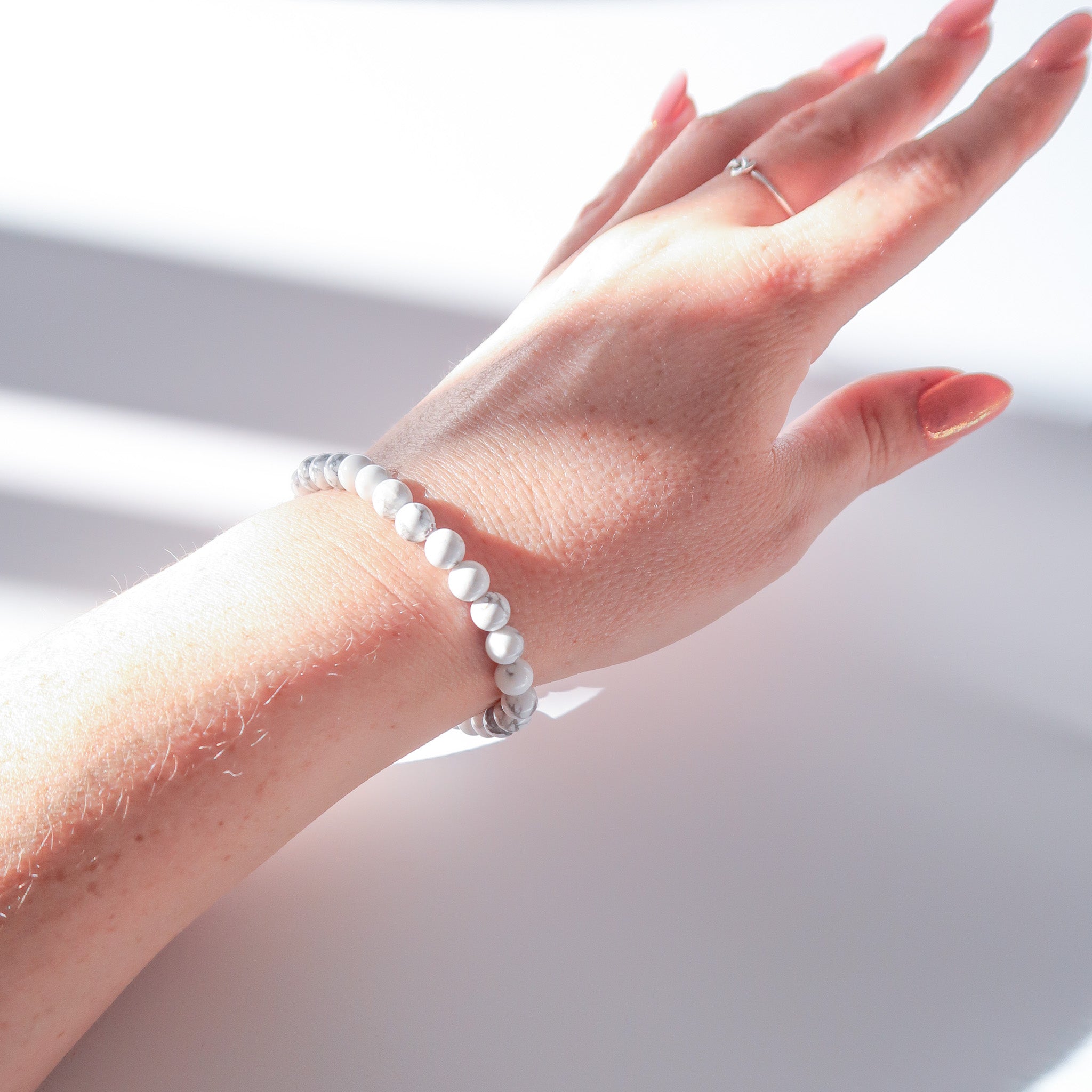 A Polished Howlite Crystal Bracelet being worn on a persons arm