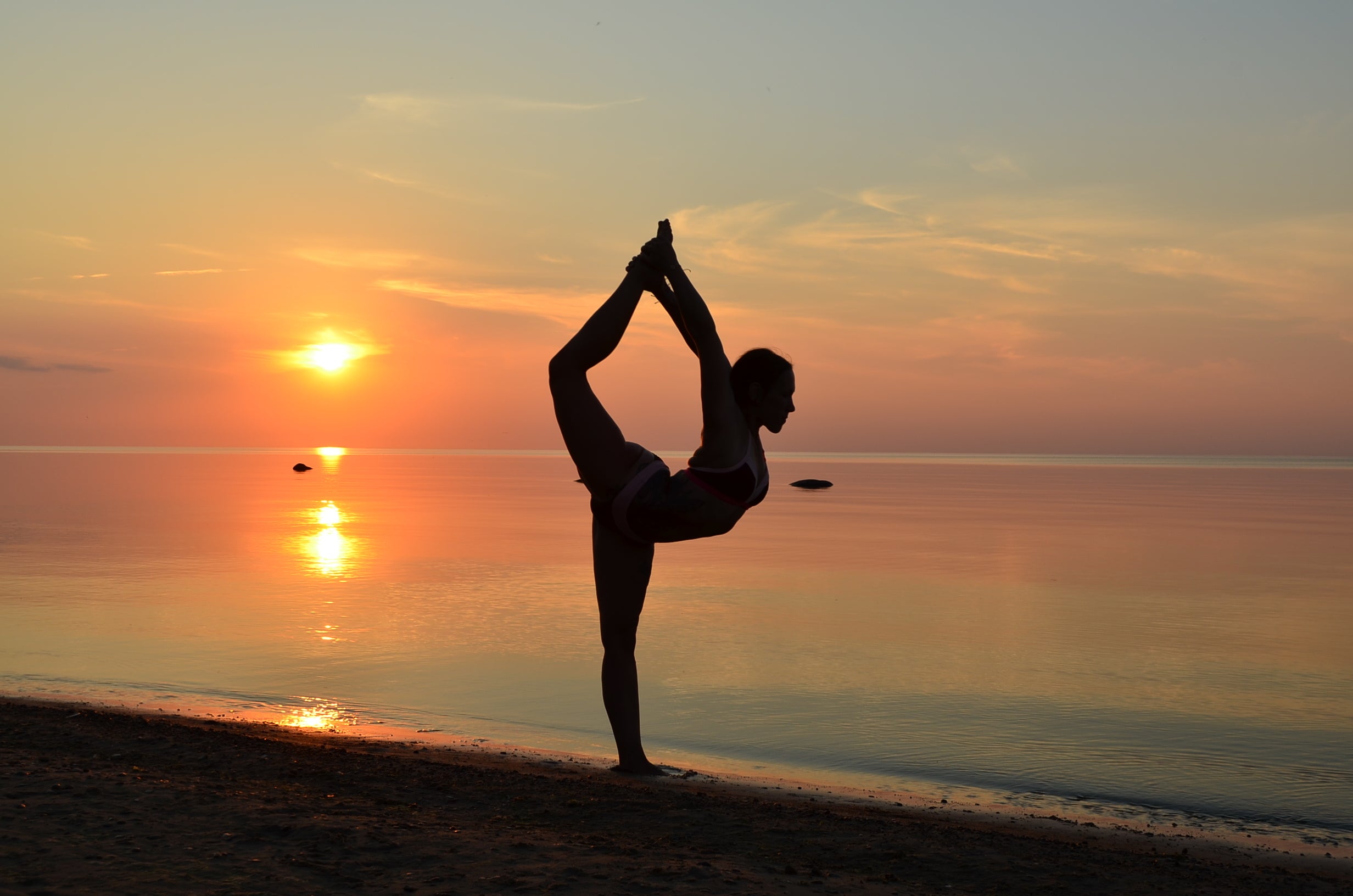 Beach yoga pose in sand at sunset